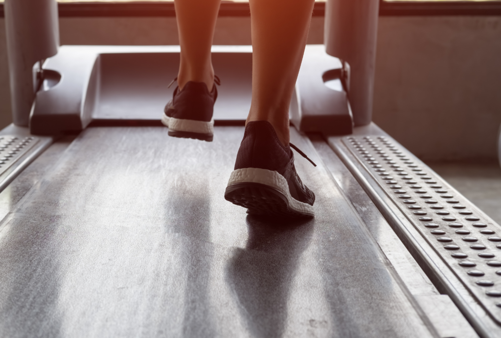 A person's feet wearing black and white running shoes on a treadmill at the Wentworth.